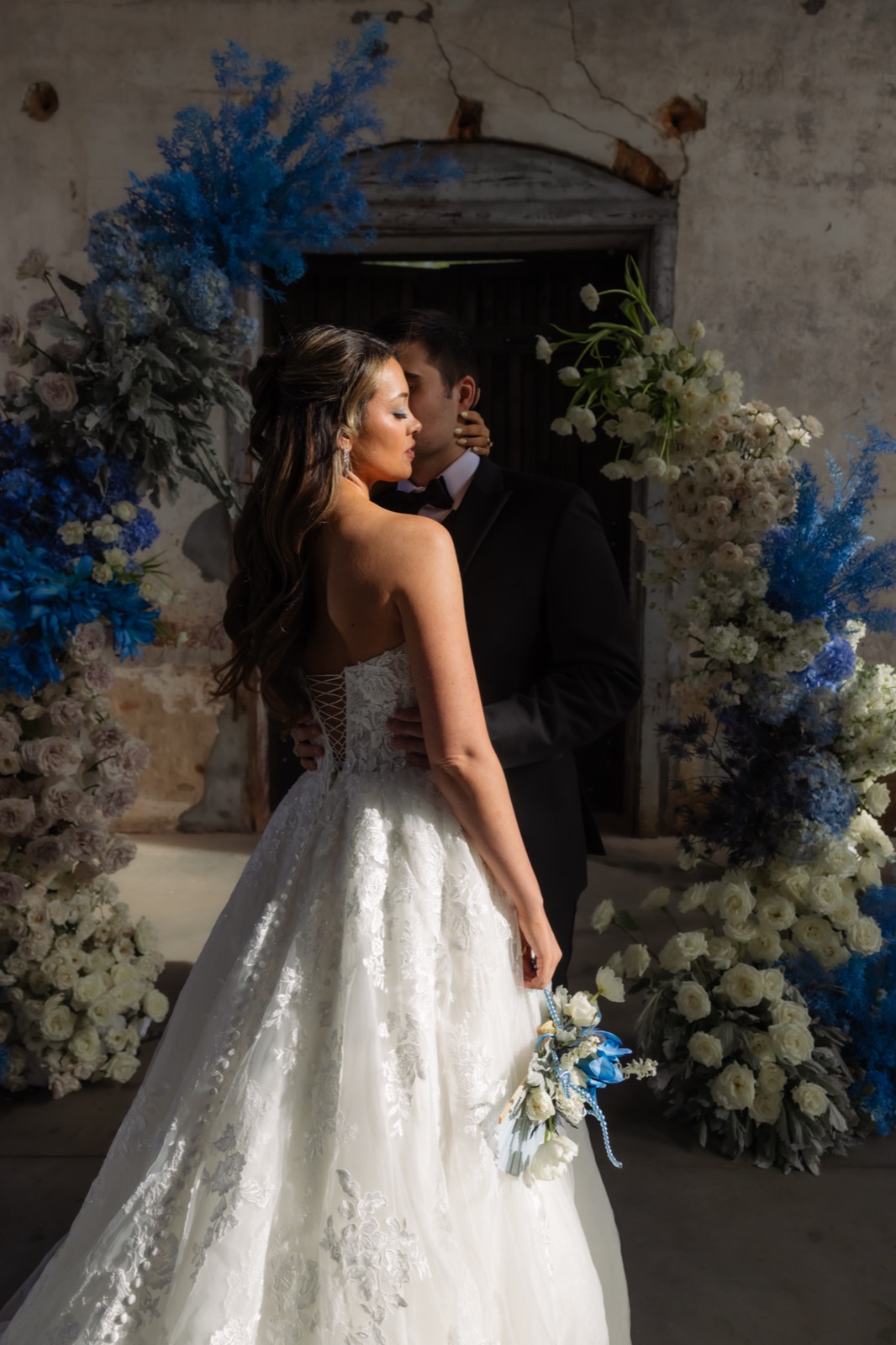 Moody color bridal portrait in front of a floral arch